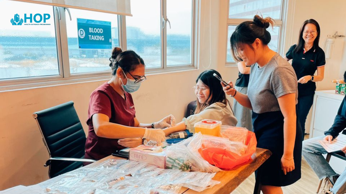 Employees participating in a corporate health screening session at a modern office. A health professional is conducting assessments in a clean, professional environment.