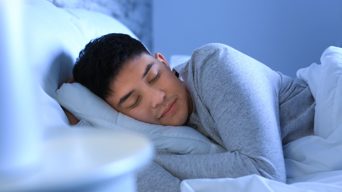 Asian man experiencing sleep debt, highlighting need for health screening sg services
