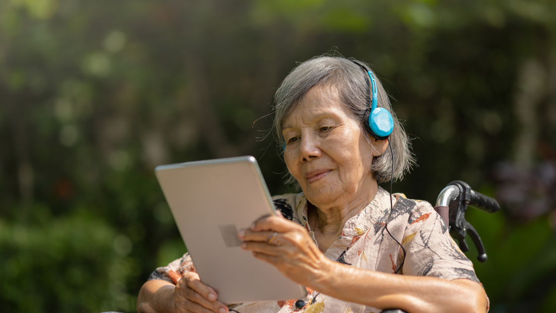 Senior lady wearing headphones and listening to music during a relaxing moment at a health screening SG centre