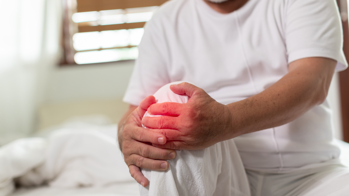 Asian man holding knee in pain showing gout symptoms in Singapore tropical climate