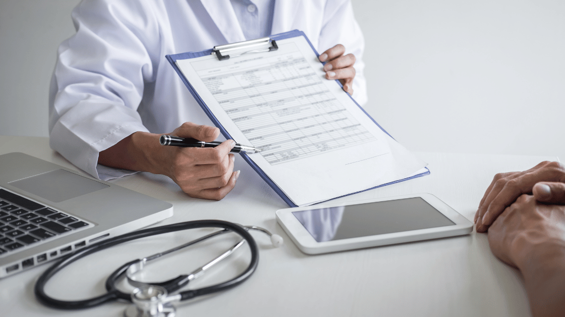 Person pointing at health screening results showing blood pressure, cholesterol and glucose levels requiring lifestyle changes