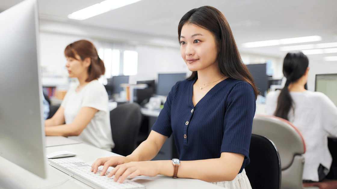 Female executive in Singapore office working on computer to schedule executive health checkup appointment