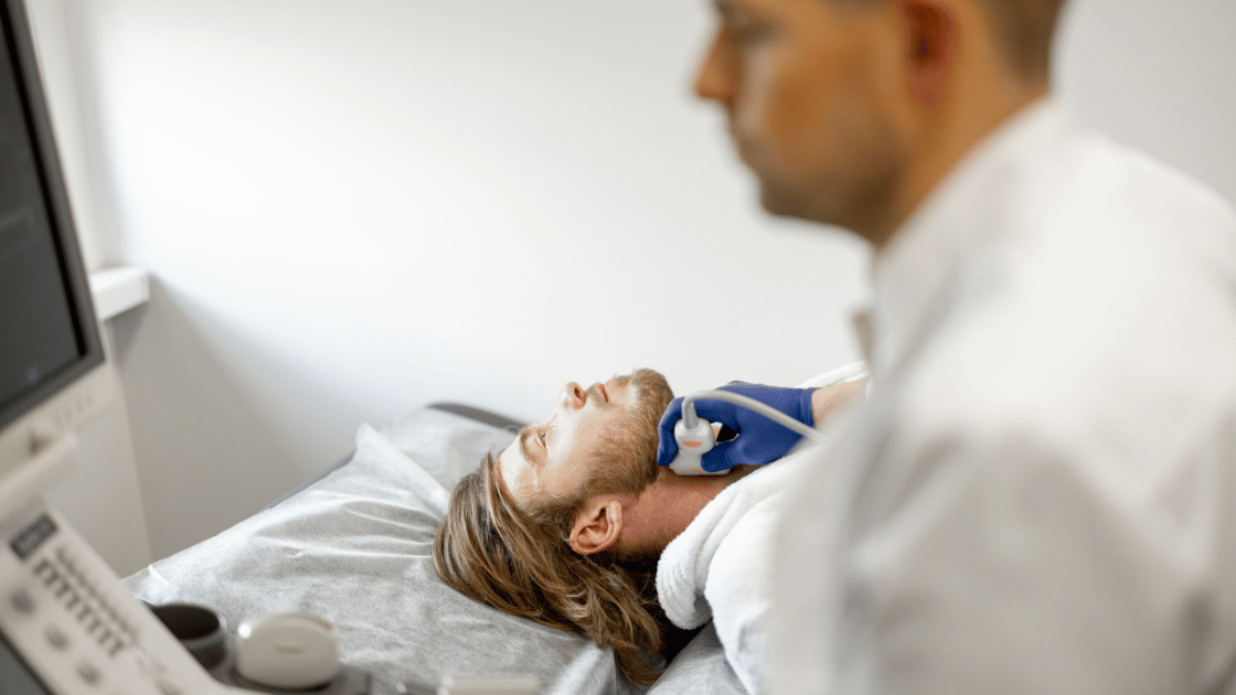 Male patient receiving carotid ultrasound screening at HOP Medical Centre Singapore with sonographer performing neck artery examination