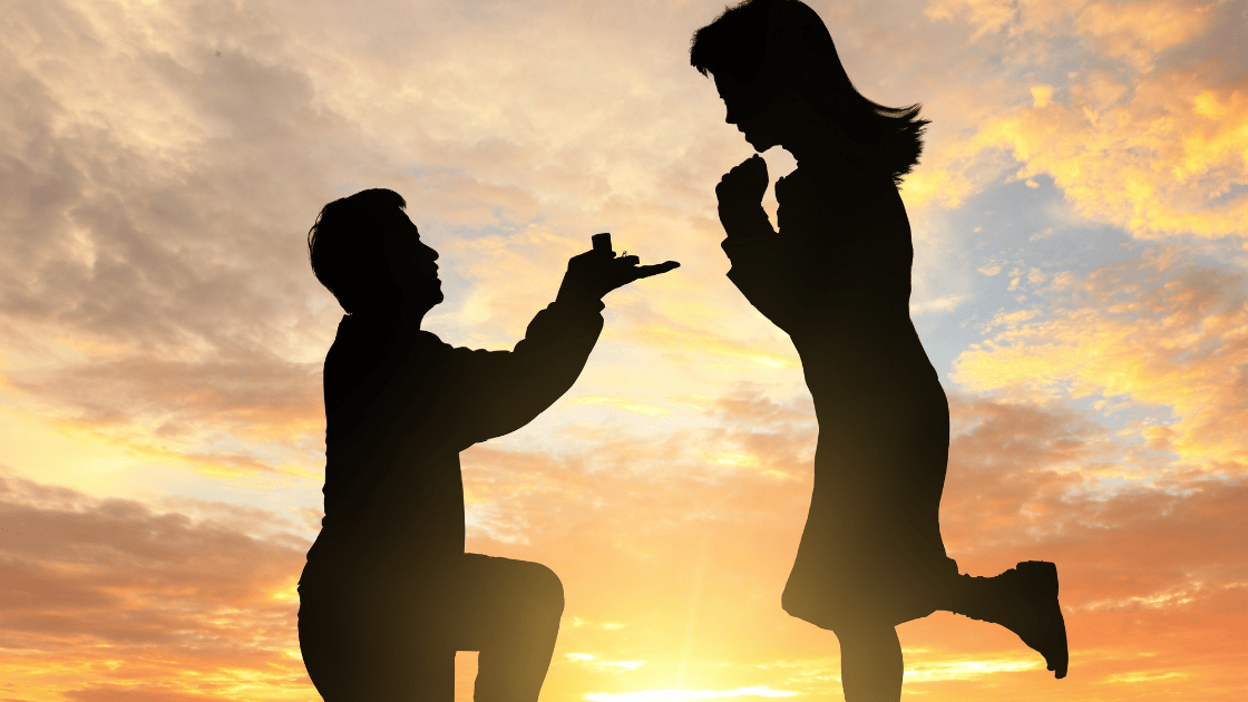 Silhouette of a man proposing on one knee to a woman, representing premarital health screening at HOP Medical Centre